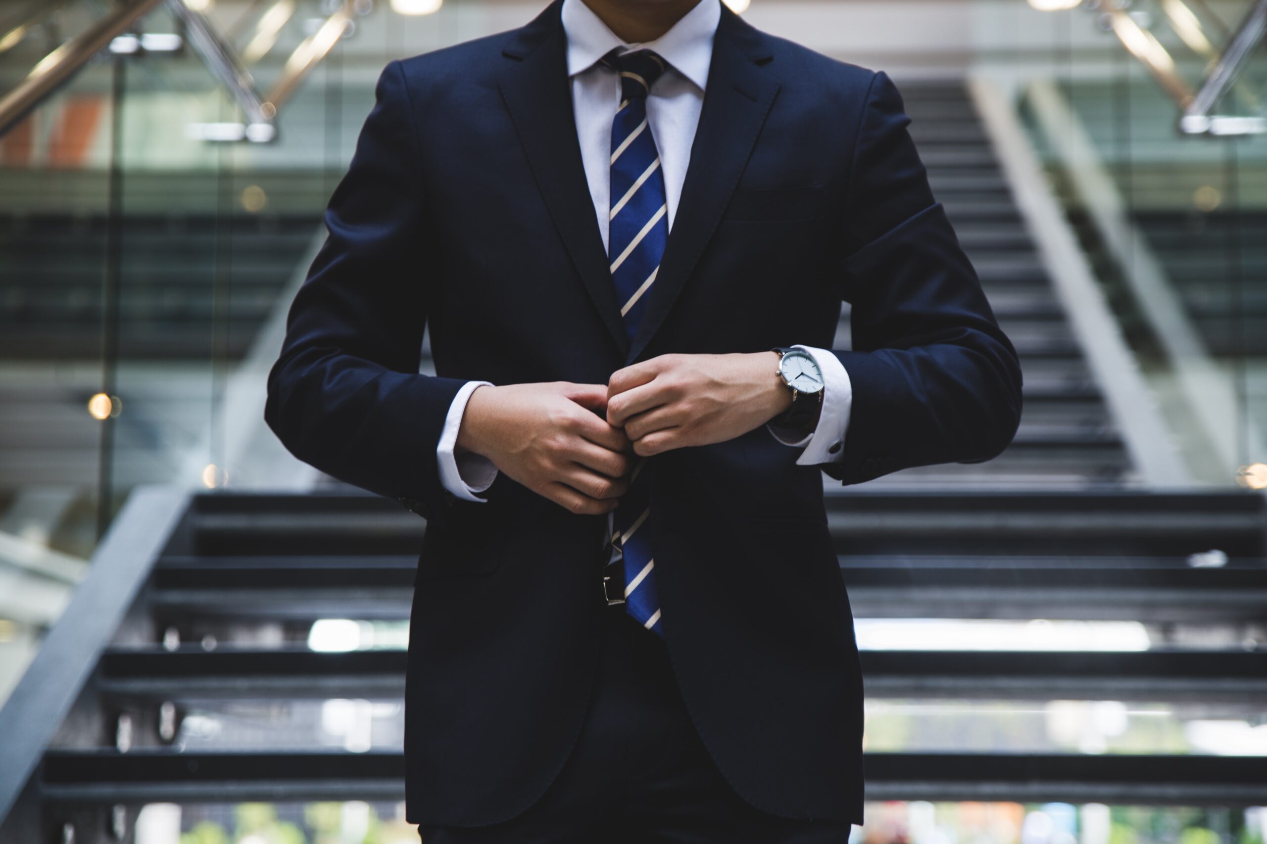 man buttoning his blazer